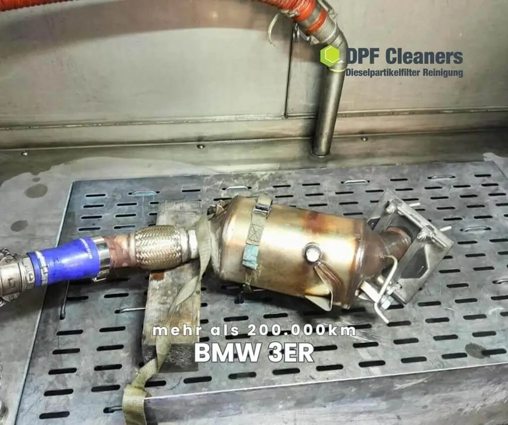 Ausgebauter BMW-3er-Partikelfilter mit Schlauchanschlüssen in der Reinigungsanlage