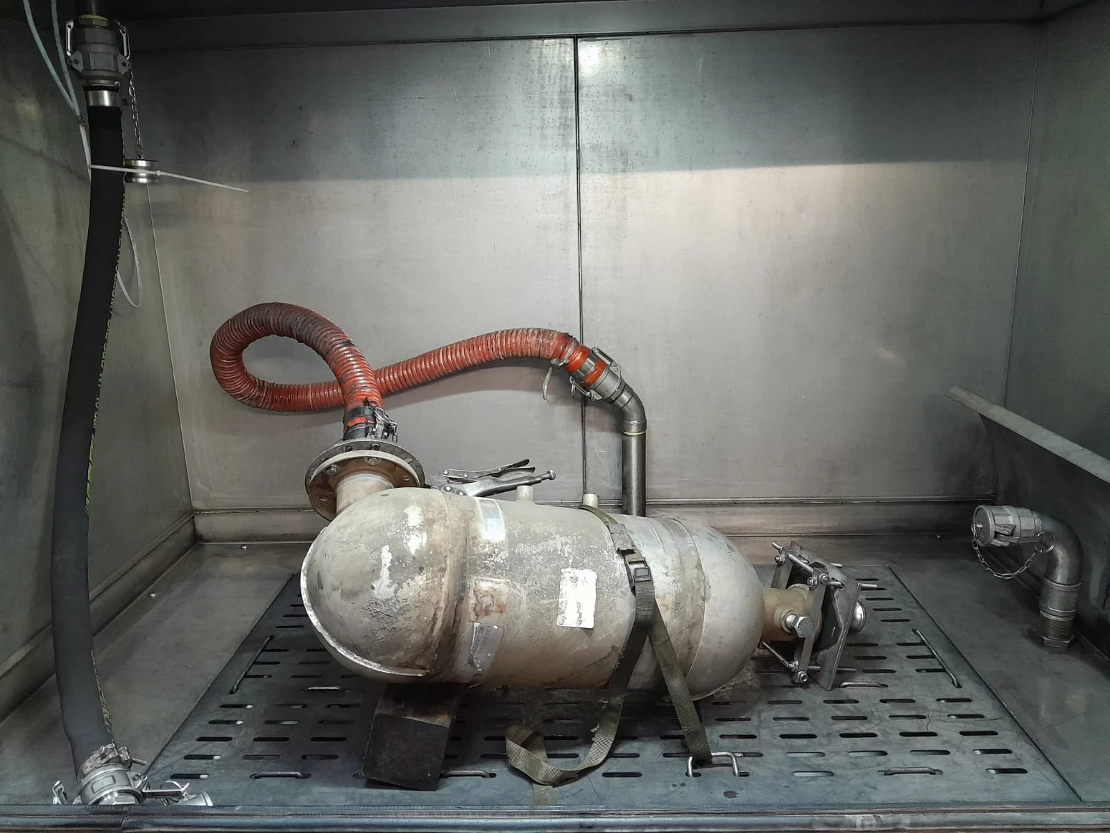 Partikelfilter eines Teleskopladers mit Schlauchanschluss in der Reinigungsanlage.
