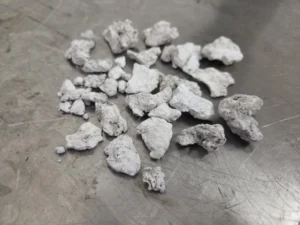 Helle, kompakte Ablagerungsstücke, die DPF Cleaners bei der Reinigung eines SCR-Bauteils herausgewaschen hat.